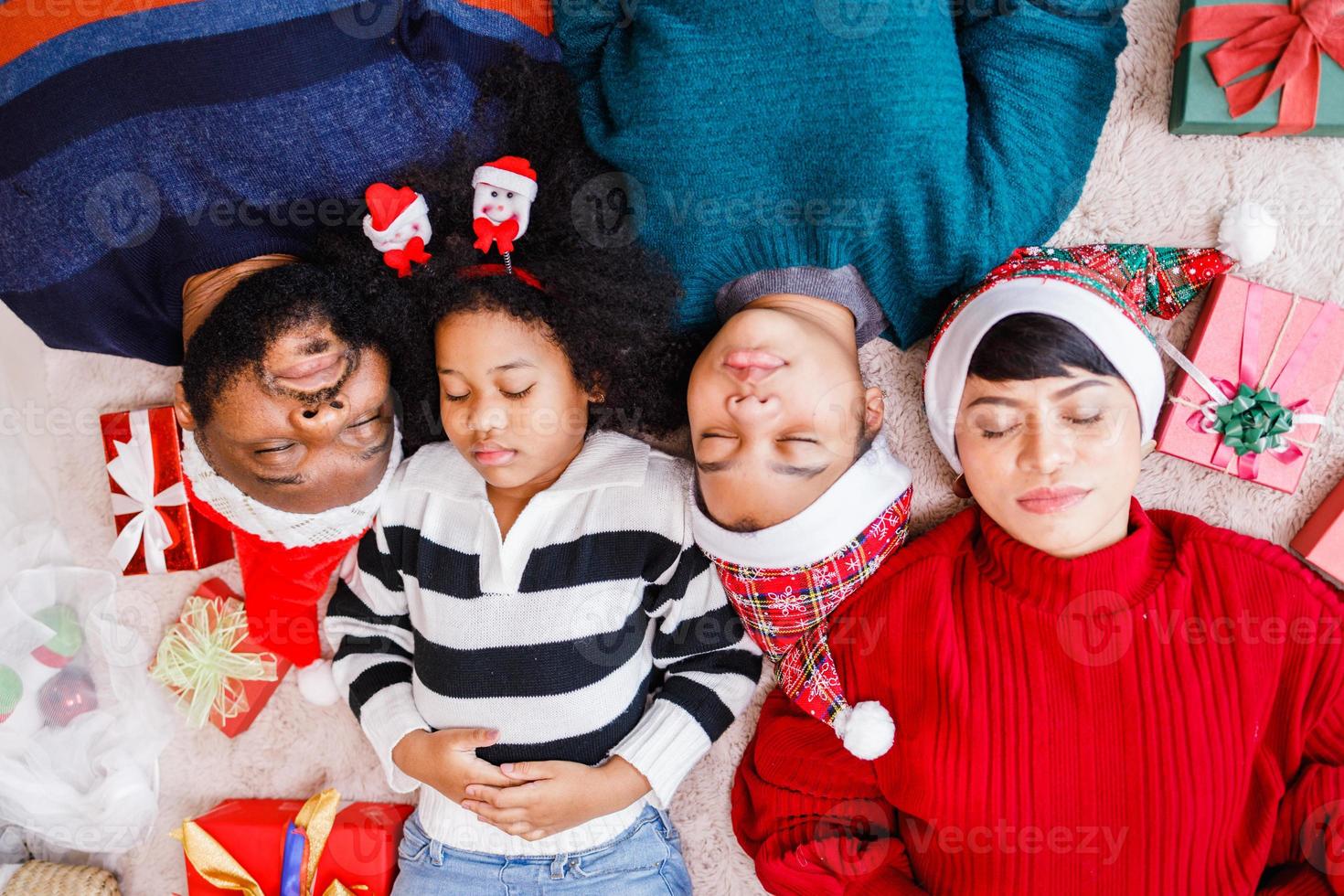 African American family in Christmas theme. Happy African American family of four bonding lying on the floor together. photo