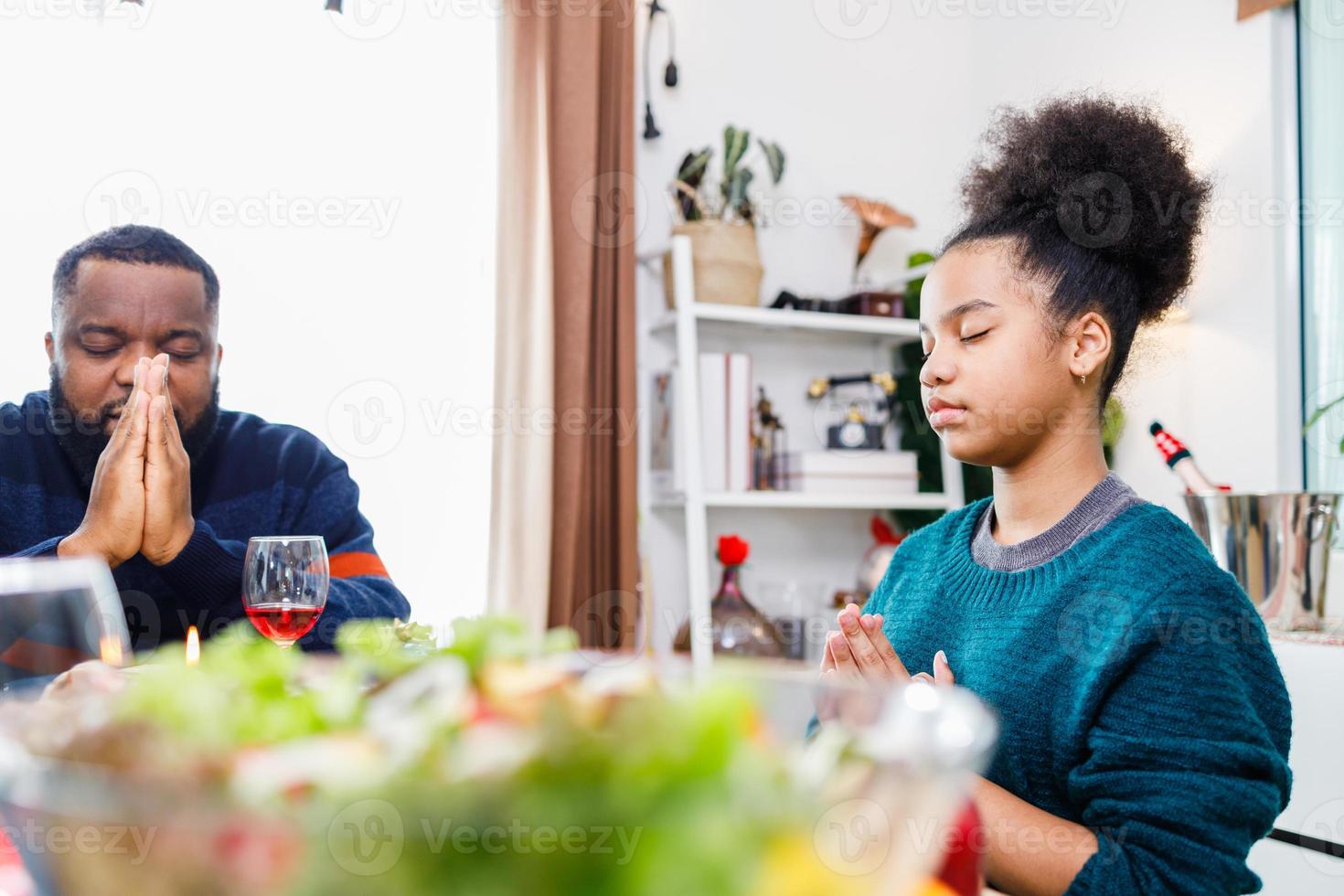 Families together to pray before meals at home. photo