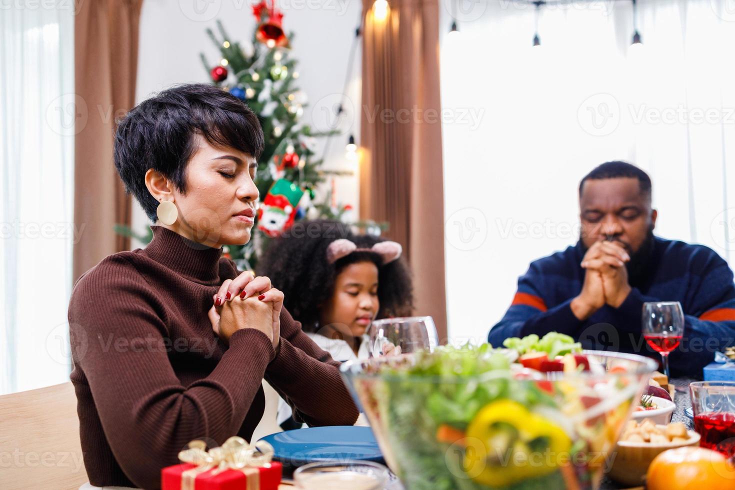 familias juntas para orar antes de las comidas en casa. foto