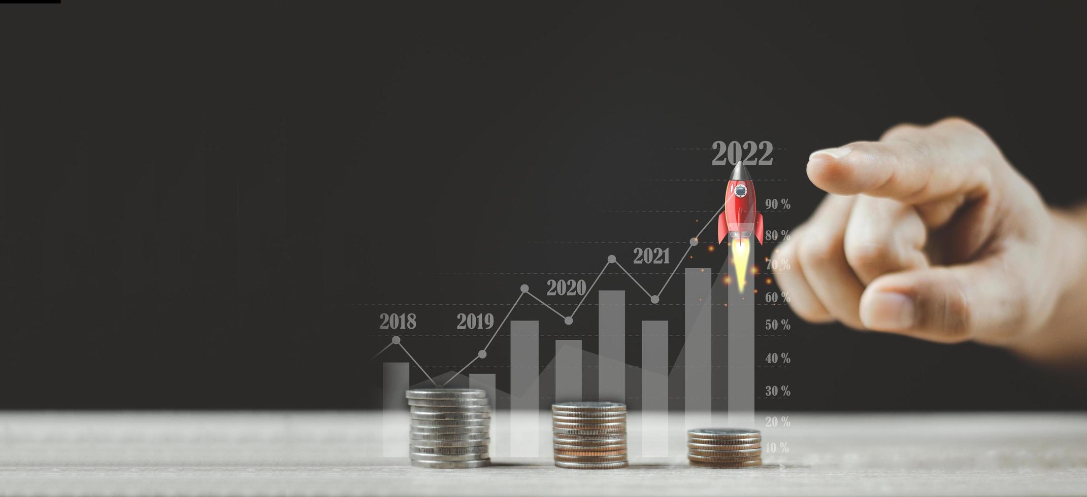 apuntando un cohete volador sobre un gráfico creciente de monedas foto