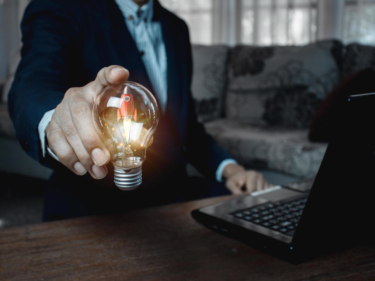 idea light bulb rocket on business man hand . photo