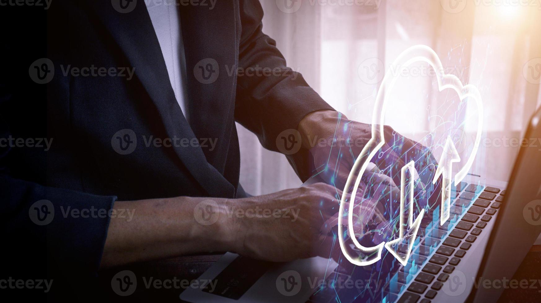 Businessman using laptop to store data with cloud computing technology photo