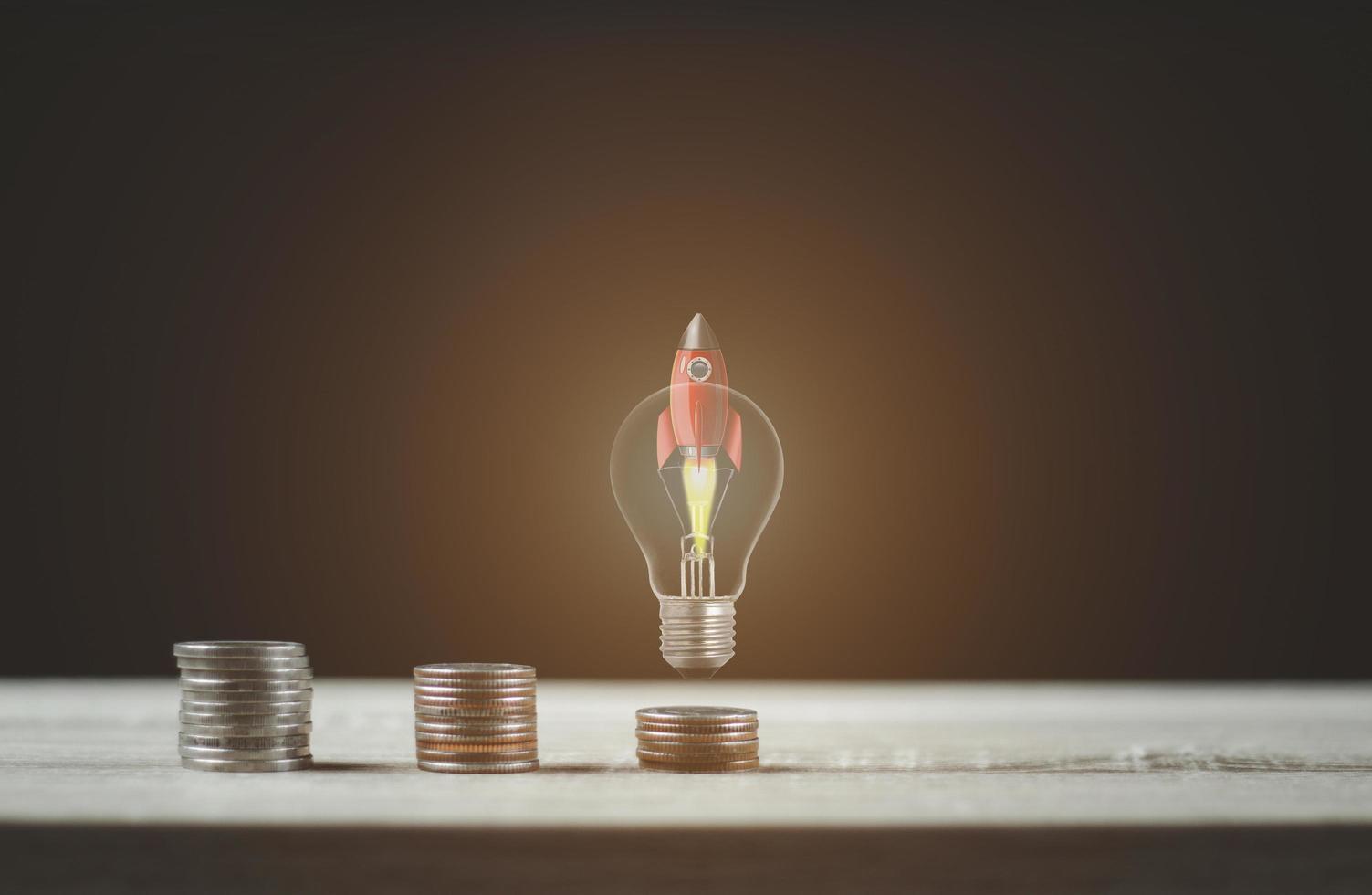 Light bulb rocket with coin ladder for financial plans . photo