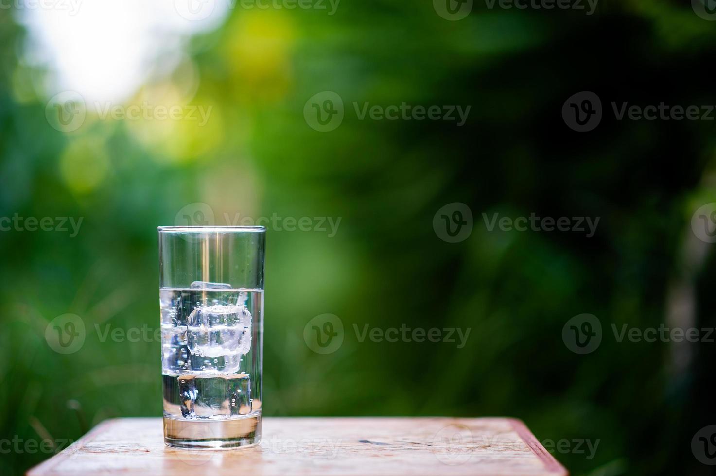 A glass of clean water with ice placed on the table ready to drink photo