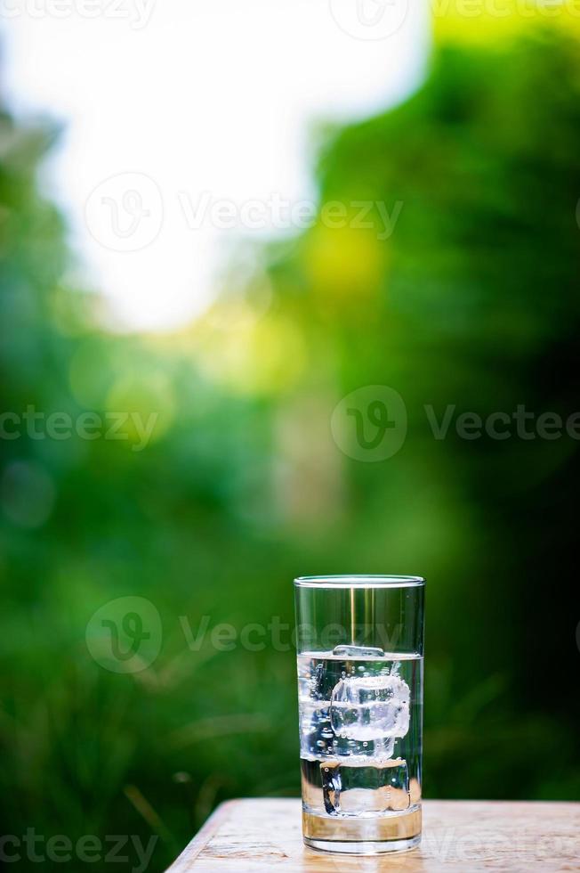 A glass of clean water with ice placed on the table ready to drink photo
