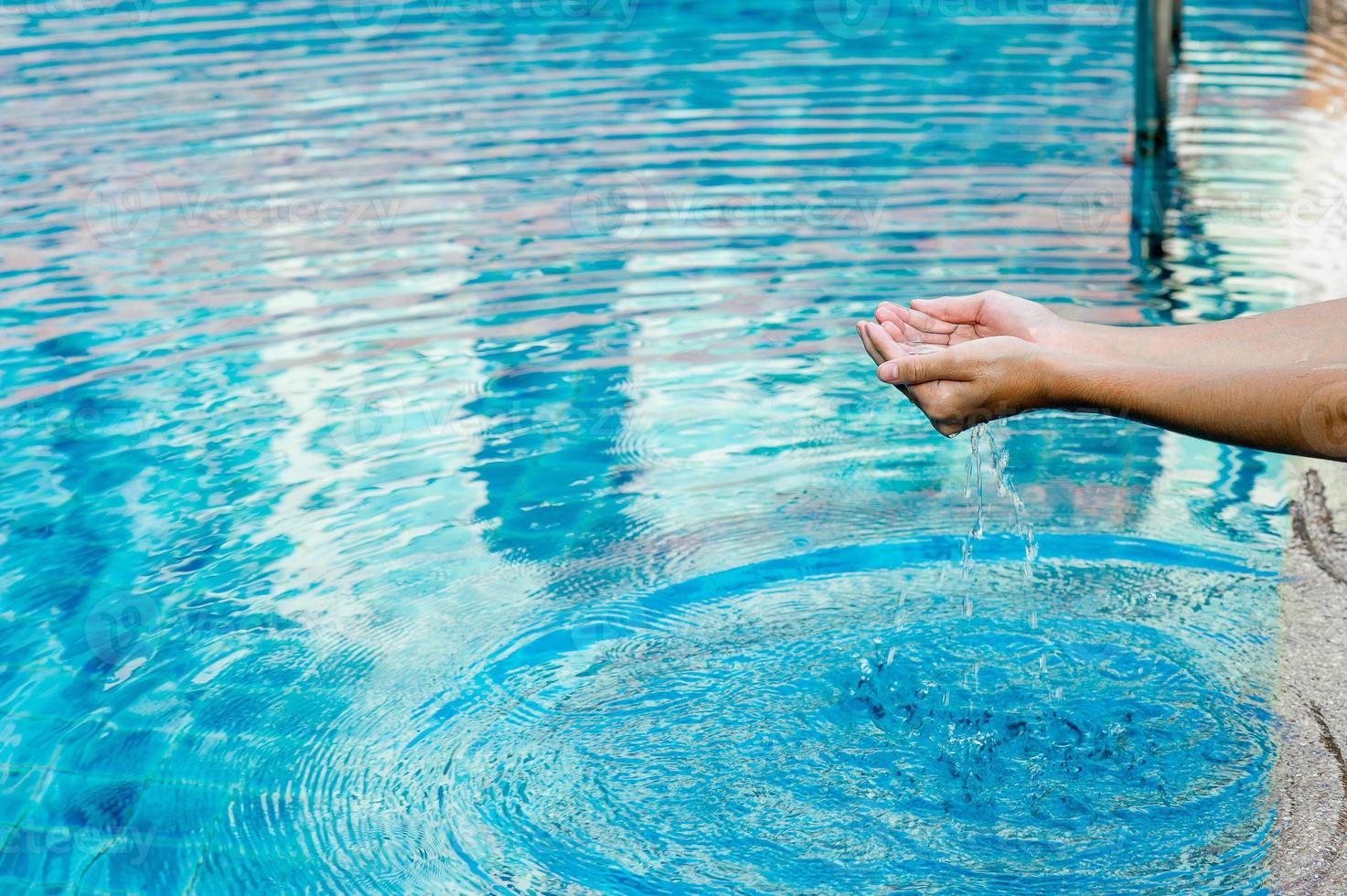 Hand and water touch the blue water. To refresh the concept of playing clean water with copy space. photo