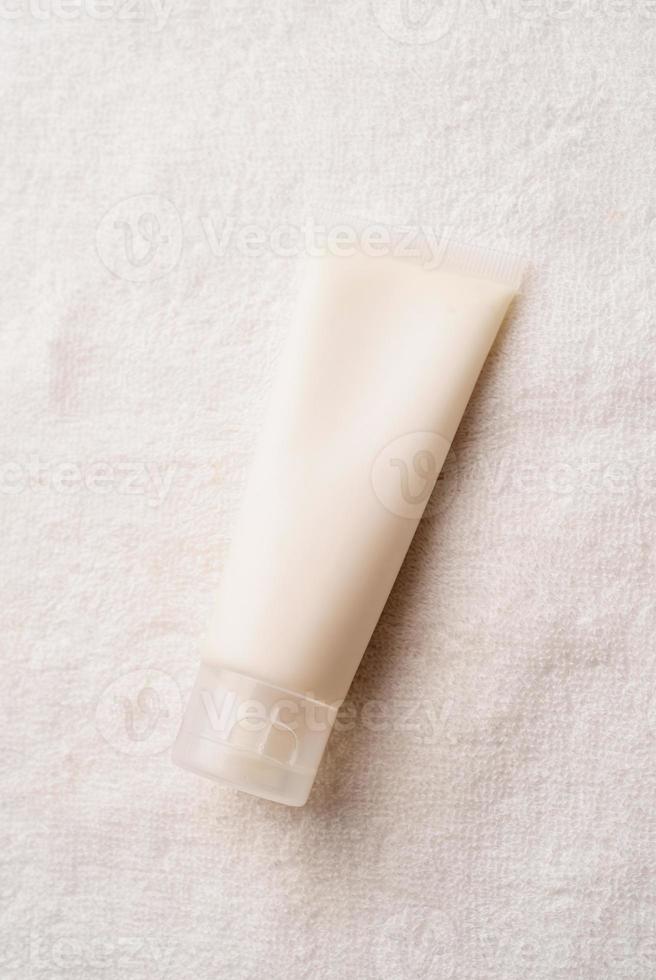 Top view Mockup facial skincare product white tube with blank label on farbic background photo