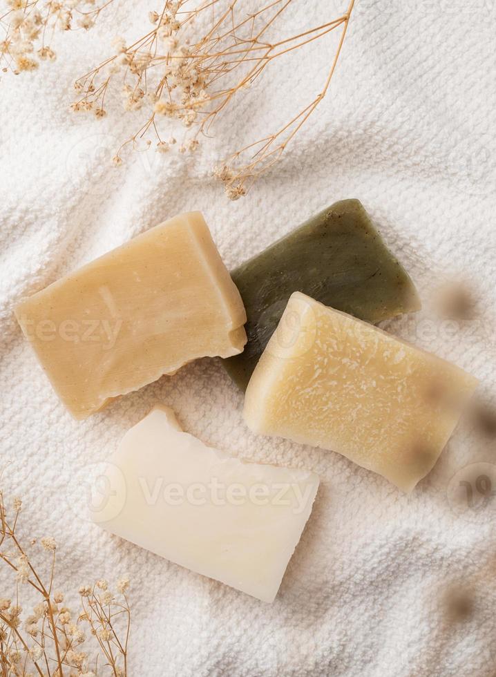 Handmade soap bars on white towel top view photo