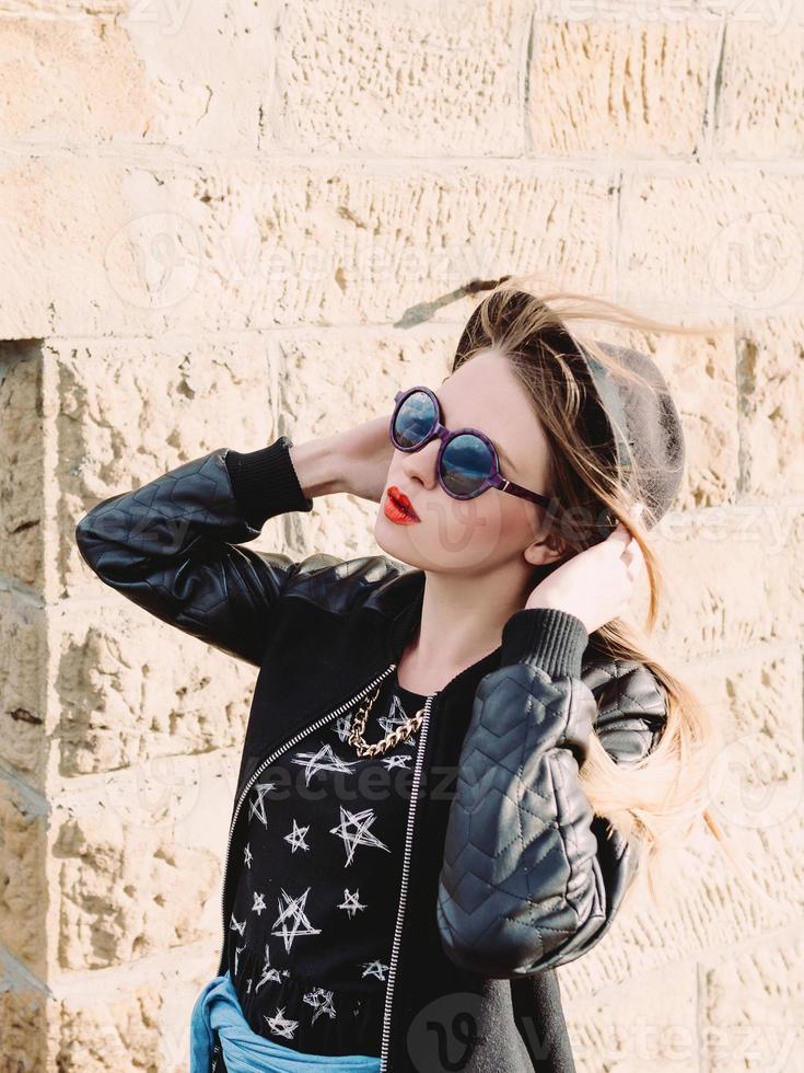 elegante viajera hipster con gafas de sol y sombrero negro junto al viejo viaducto del puente. viajar, europa, moda, concepto de estilo foto