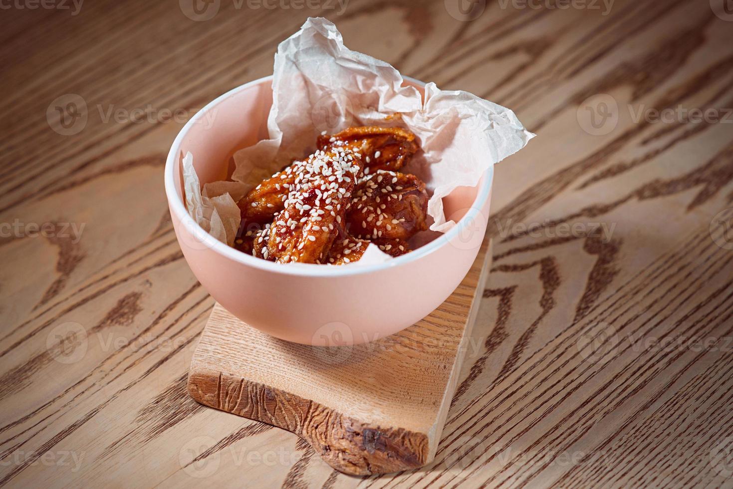 fried chicken wings with sesame in the plate on the table photo