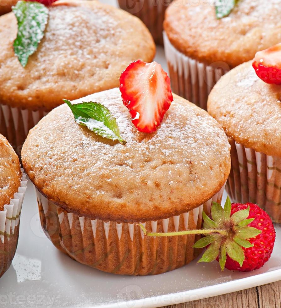 Strawberry muffin on a white plate with a fresh strawberry photo