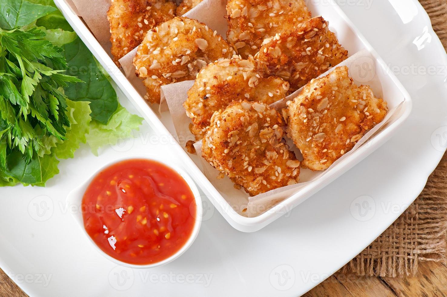 Chicken nuggets coated in cereals, crumbs and sesame photo