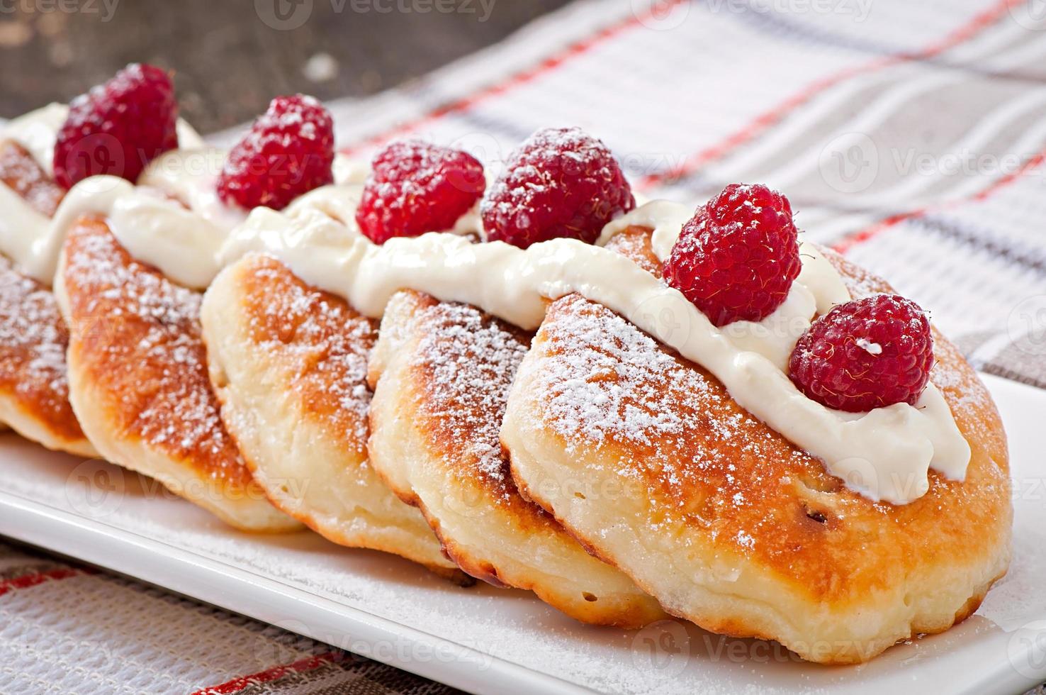 pasteles de queso con crema agria decorados con bayas foto