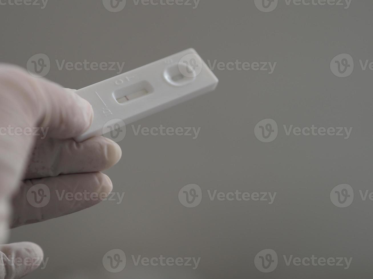 Asian woman wear rubber gloves hold ATK Antigen test kit covid-19 virus test photo