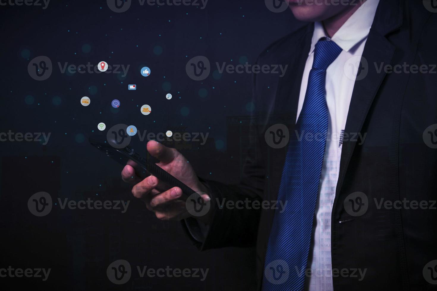 Businessman in black suit communicates with a virtual digital phone screen online. photo
