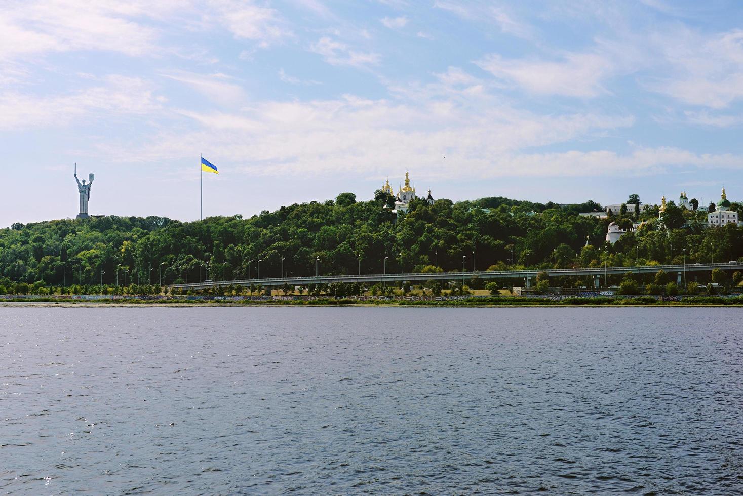KYIV, UKRAINE, 2020 - Cityscape from the water of the Mother Motherland monument and Kyiv-Pechersk Lavra on green heels. photo