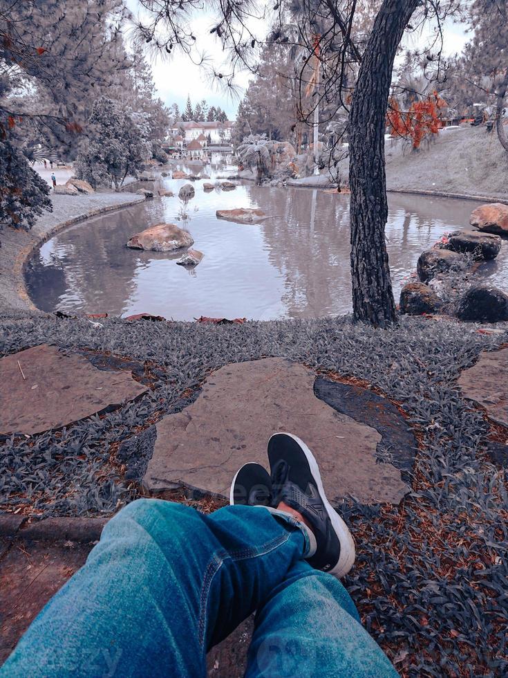 legs crossed looking at the lake photo