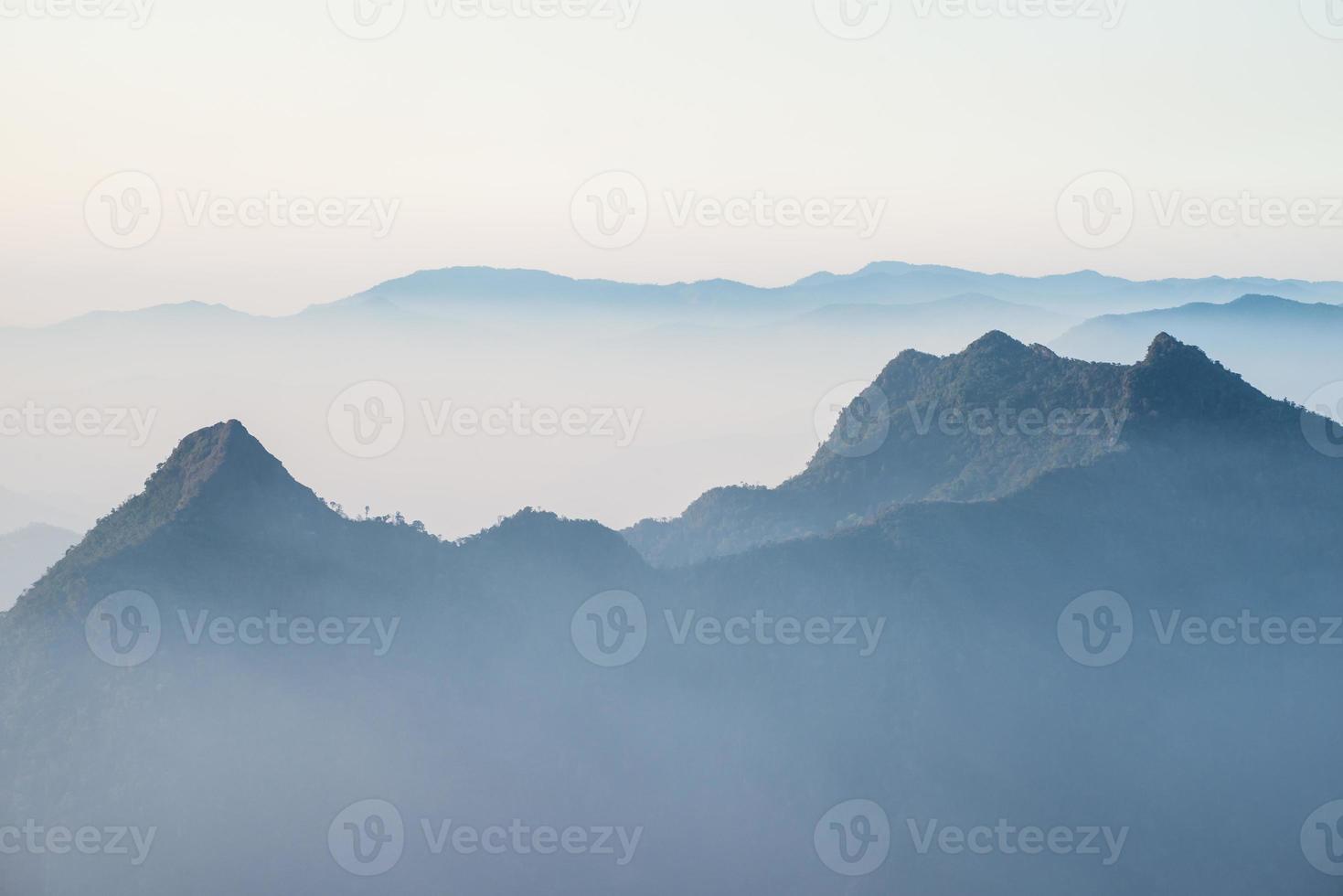 Scenery view of the mountains in the mist layer background. View from Phu Chi Fah in Chiang Rai province of Thailand. photo