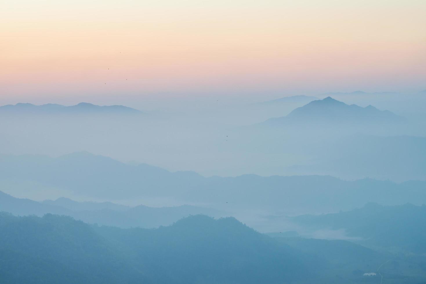 Scenery view of the mountains in the mist layer background. View from Phu Chi Fah in Chiang Rai province of Thailand. photo