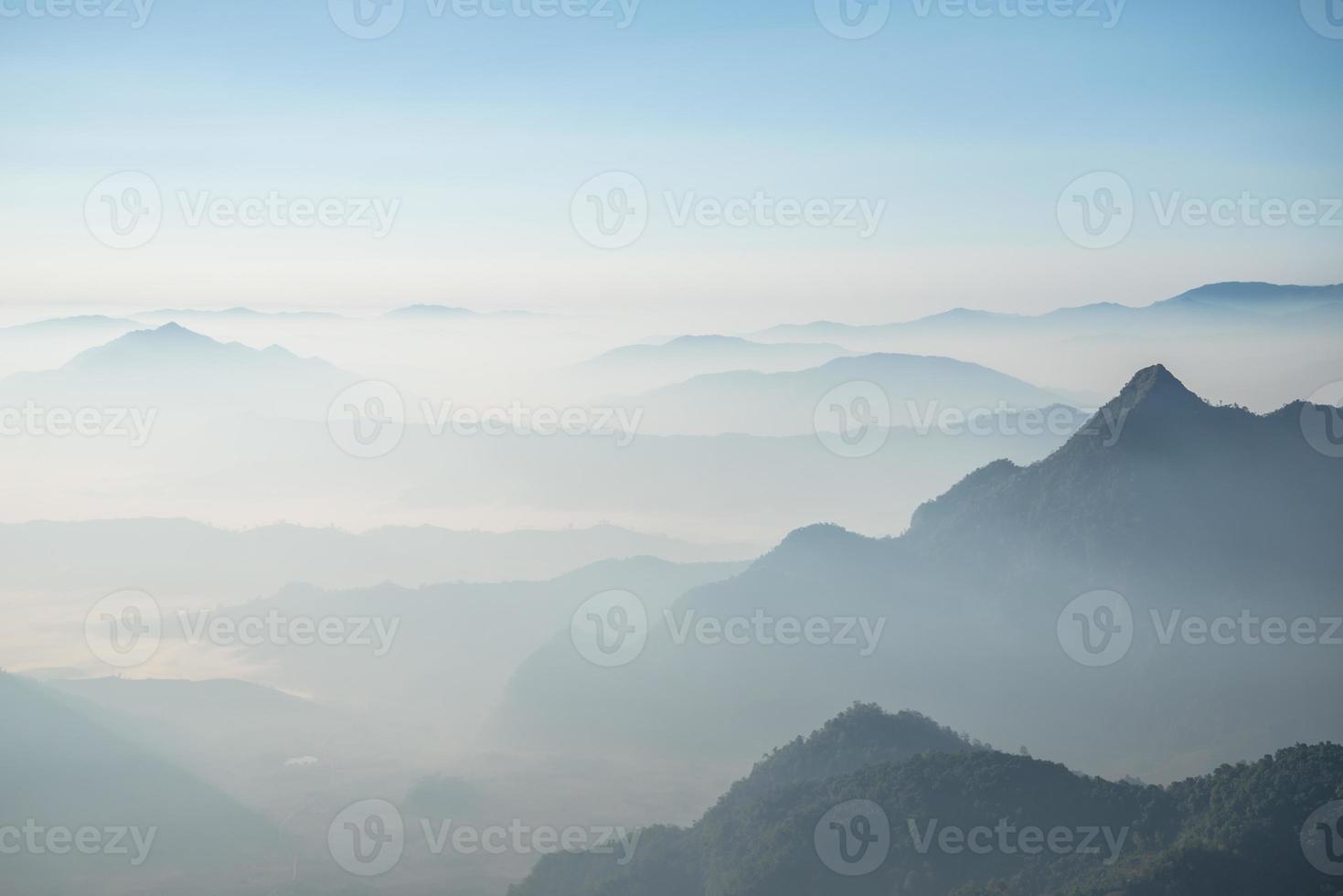 Scenery view of the mountains in the mist layer background. View from Phu Chi Fah in Chiang Rai province of Thailand. photo