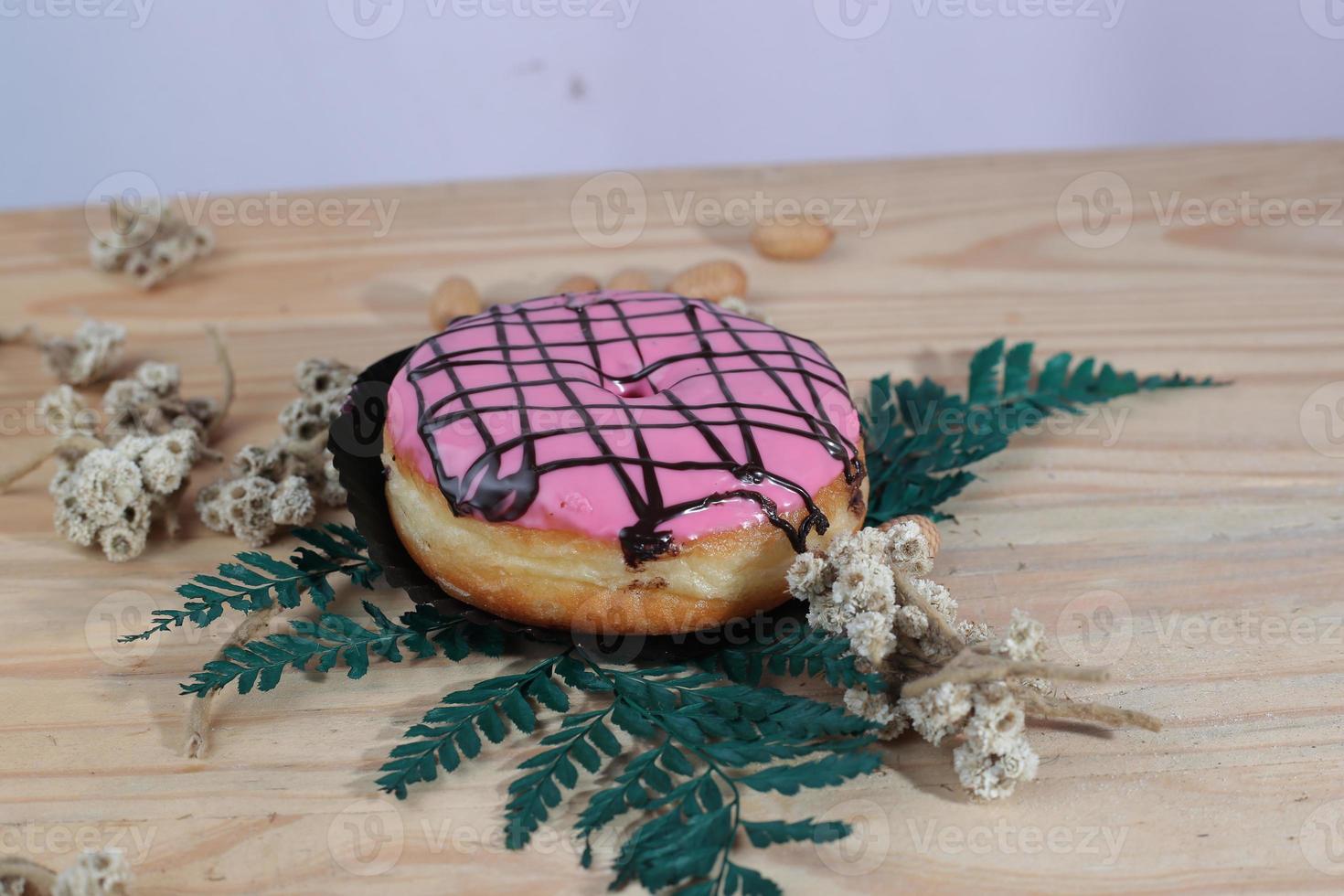 Brown donuts with sprinkles isolated on a wooden background photo
