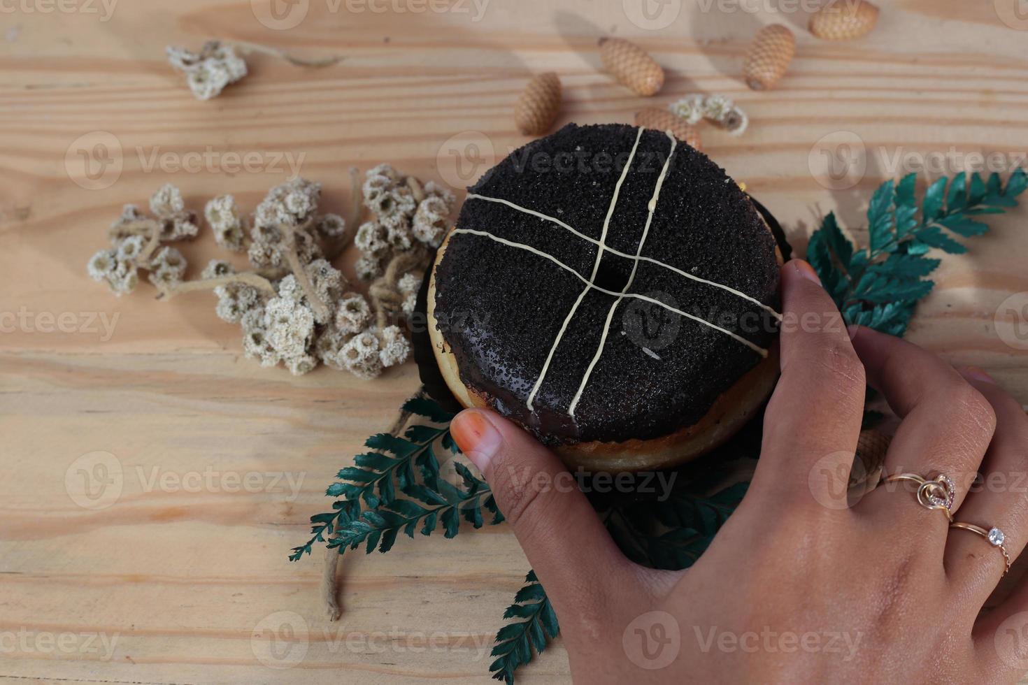 Brown donuts with sprinkles isolated on a wooden background photo