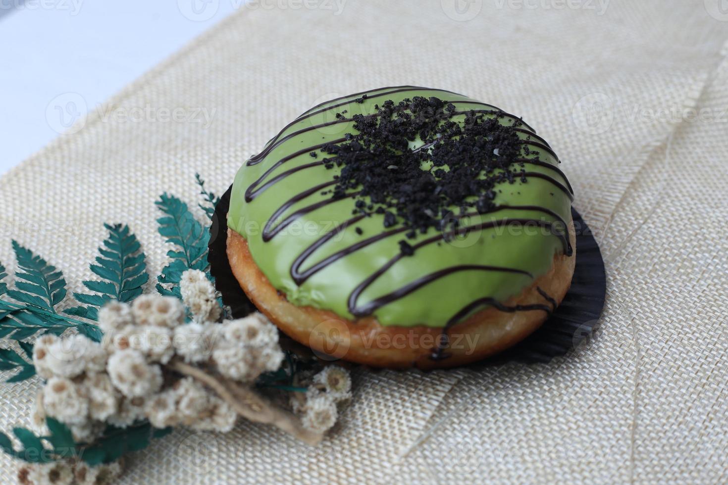 Brown donuts with sprinkles isolated on a wooden background photo