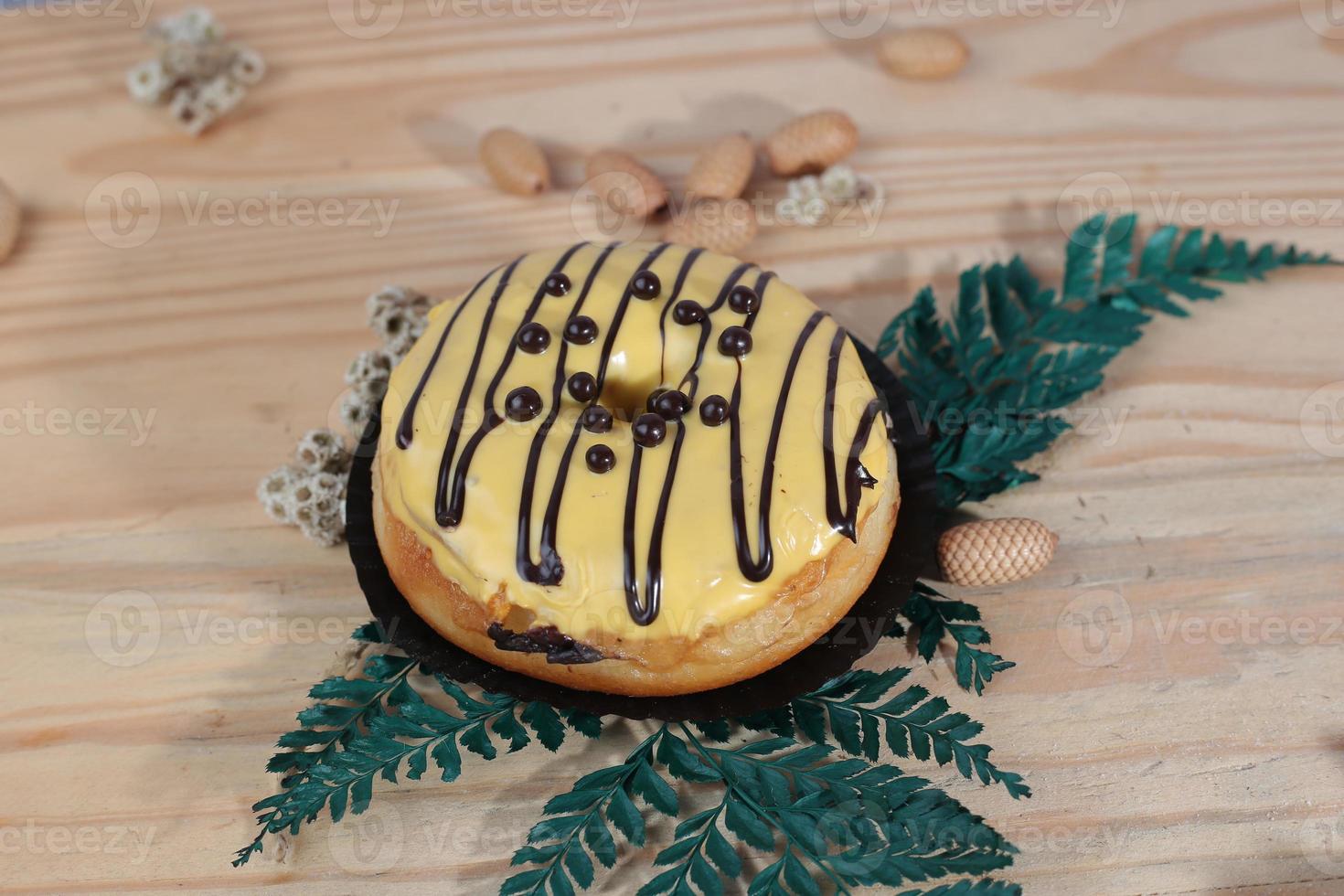 Brown donuts with sprinkles isolated on a wooden background photo