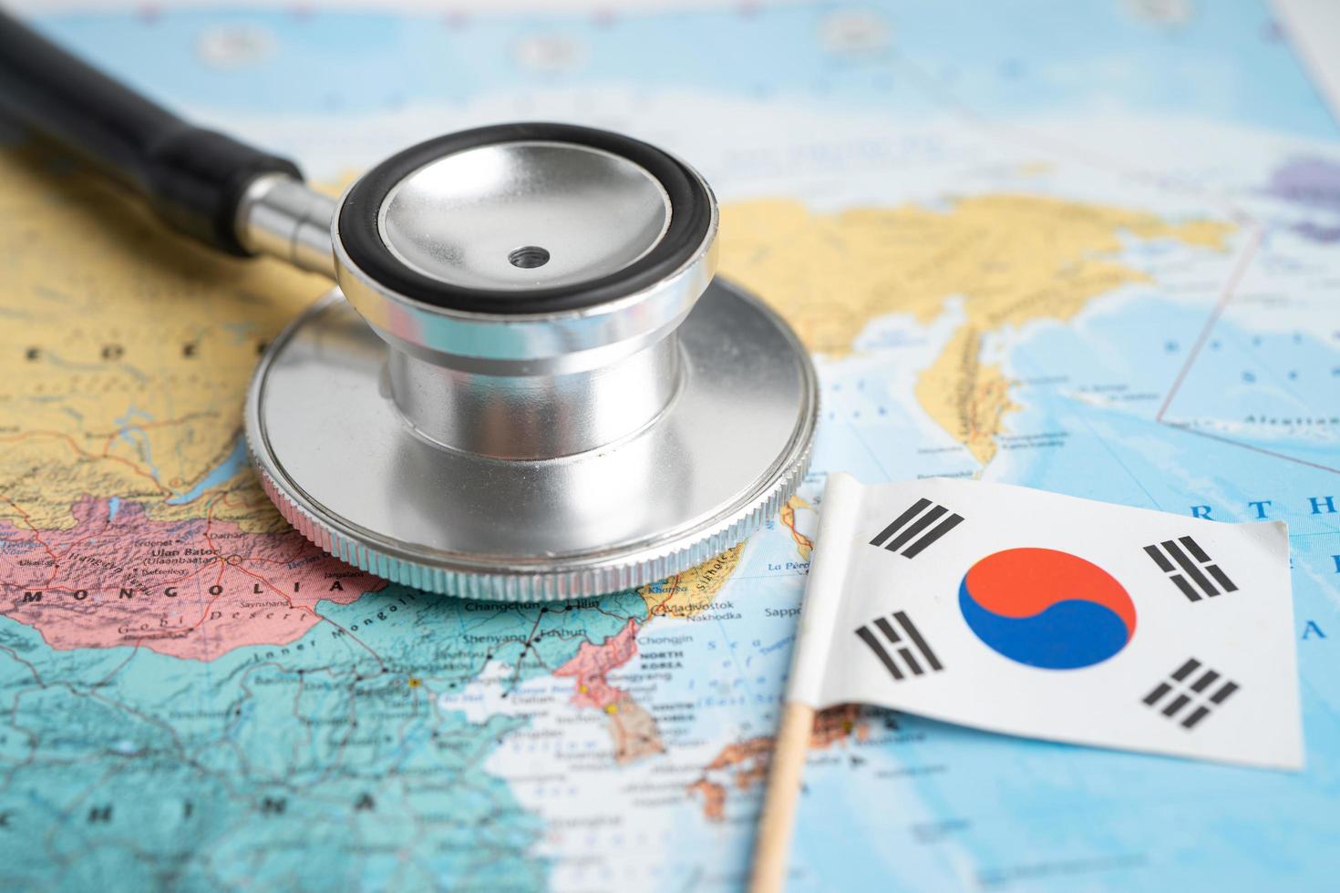 Bangkok, Thailand - February 1, 2022 Black stethoscope with Korea flag on world map background, Business and finance concept. photo