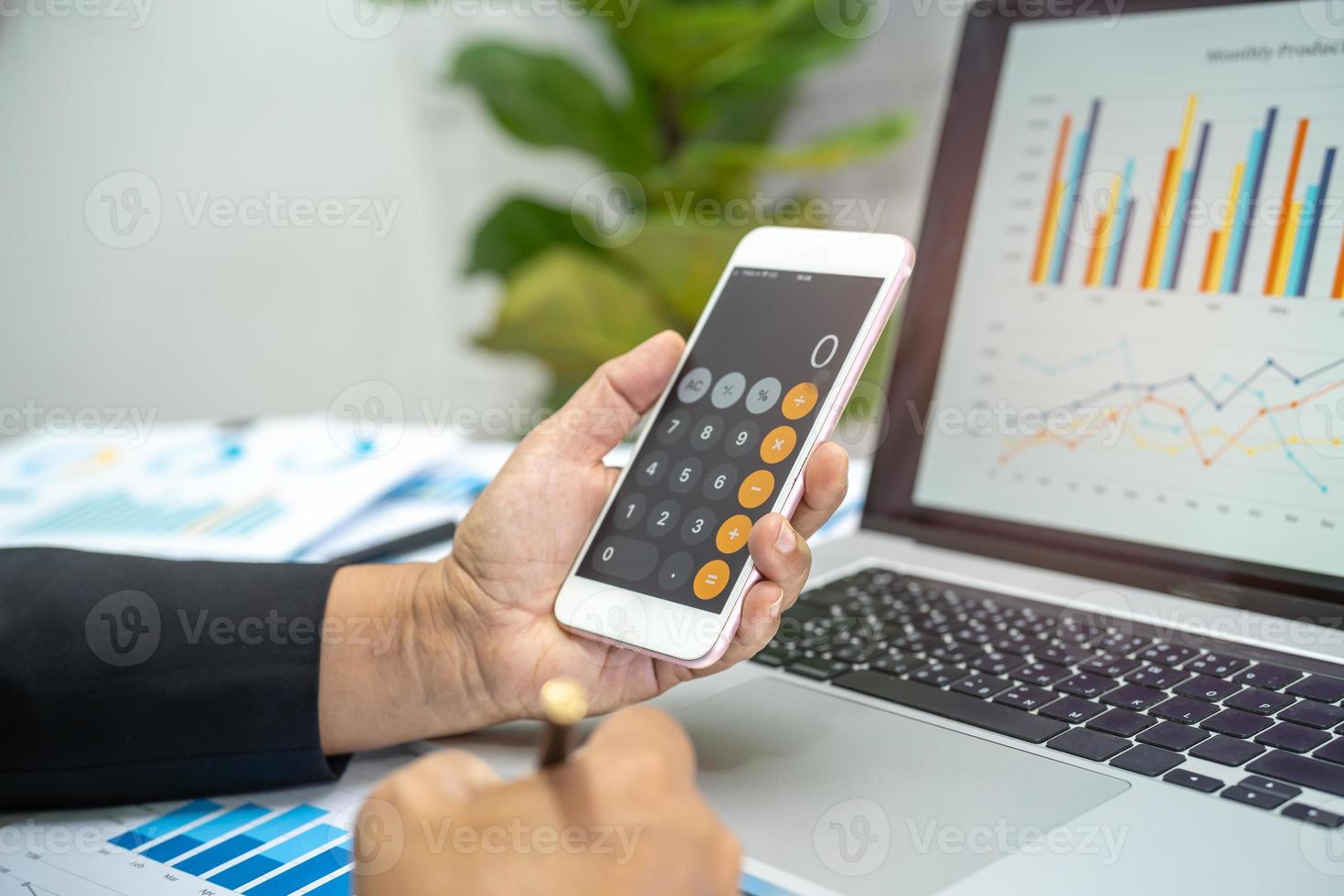 Asian accountant working and analyzing financial reports project accounting with chart graph and calculator in modern office, finance and business concept. photo