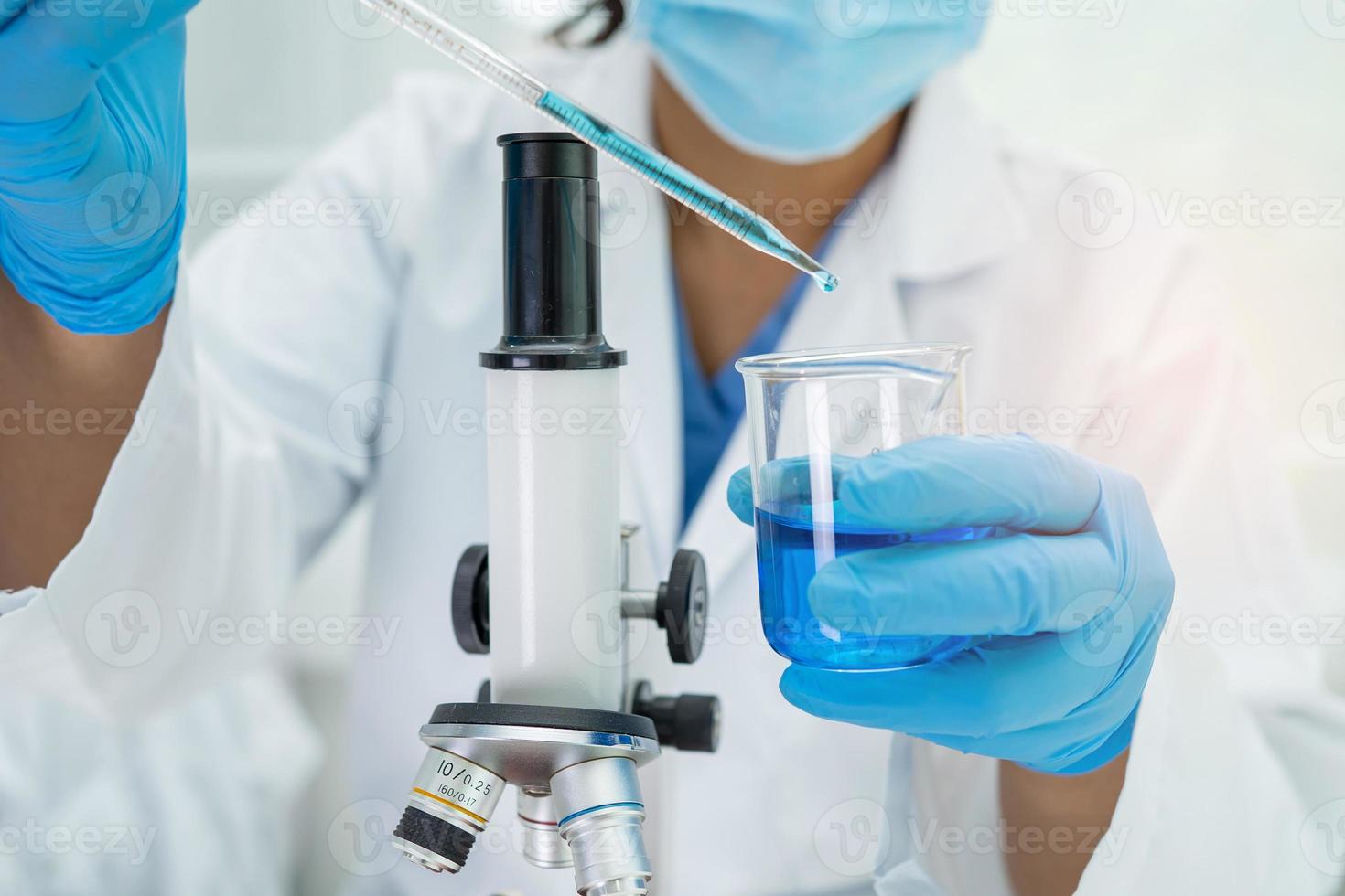 Asian scientist biochemist or microbiologist working research with a microscope in laboratory. For protect outbreak Coronavirus Covid19, bacteria and germs. photo