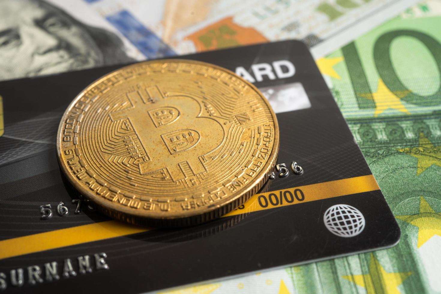 bitcoin de oro con tarjeta de crédito en dólares estadounidenses y billetes en euros para el intercambio electrónico mundial de dinero virtual, cadena de bloqueo, criptomoneda foto