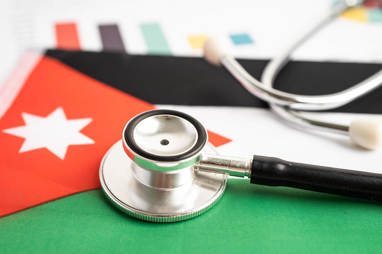Black stethoscope on Jordan flag background with graph, Business and finance concept. photo