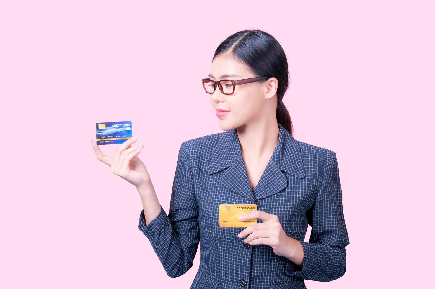 A beautiful Asian woman is happy and thinks that she will spend with many of her credit cards photo