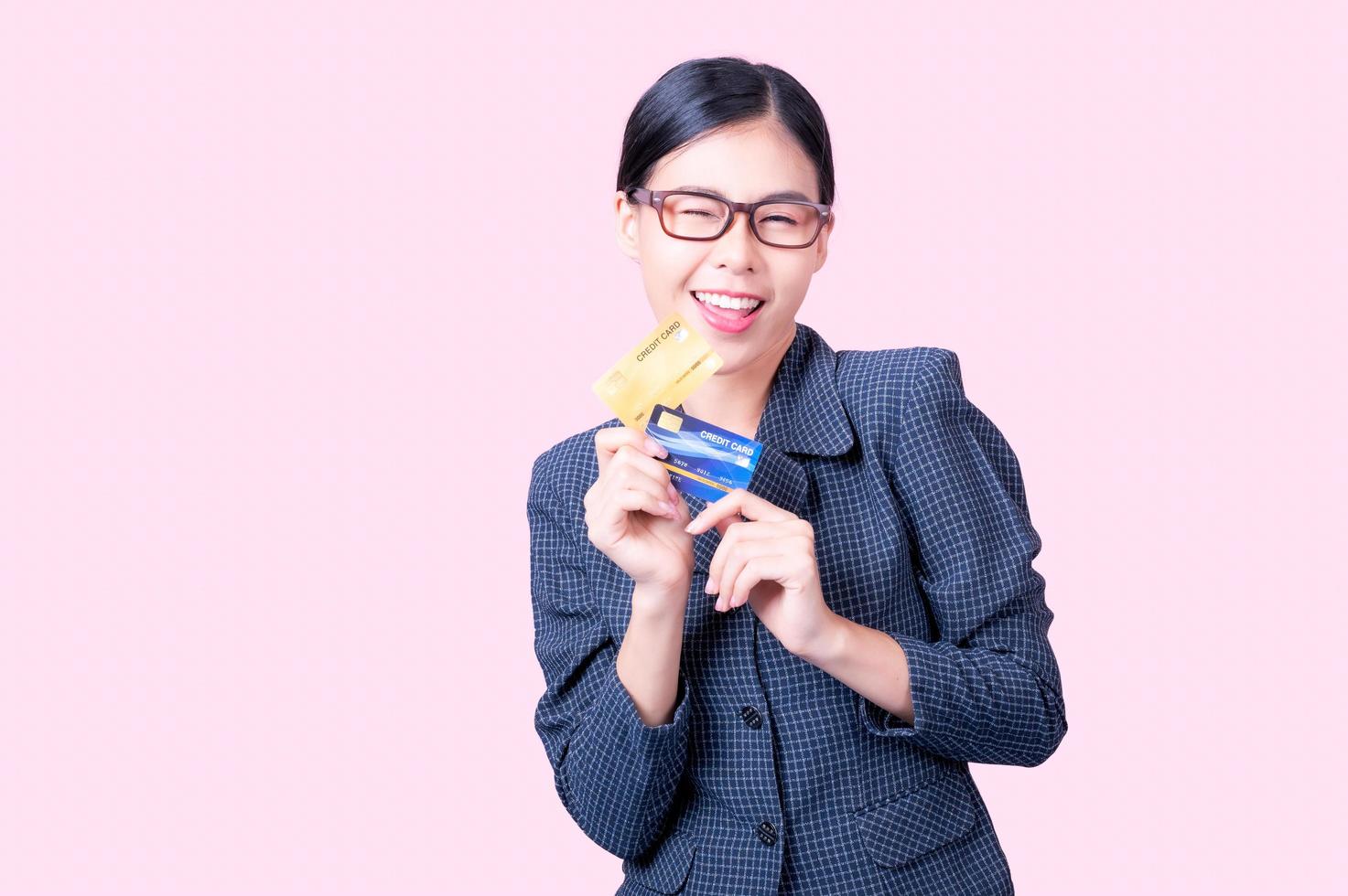 A beautiful Asian woman is happy and thinks that she will spend with many of her credit cards photo