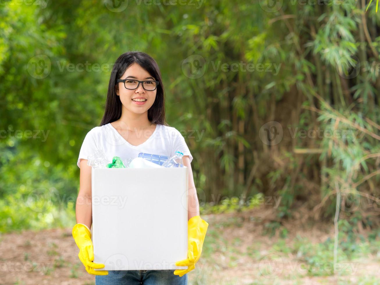 mujeres voluntarias recogen botellas de agua de plástico en el área del parque foto