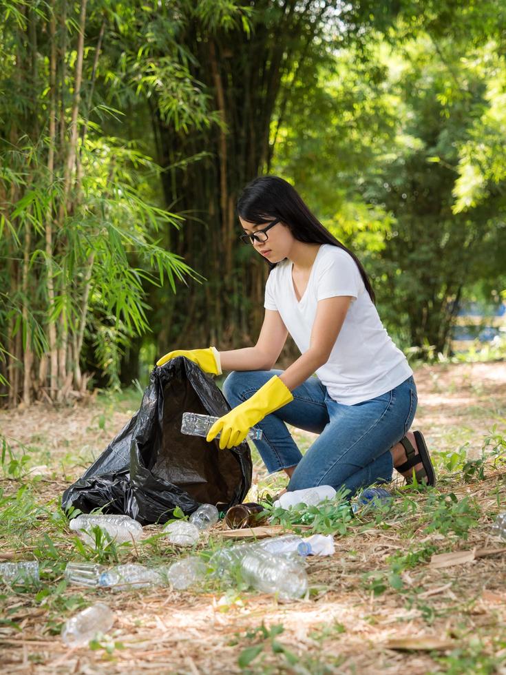 Volunteer women collect plastic water bottles in the park area photo