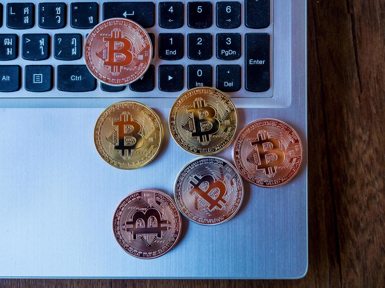 Los bitcoins son de cobre, oro y plata, que se encuentran en la moneda digital. sobre un fondo de teclado foto