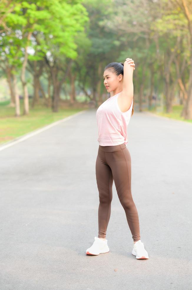 hermosas mujeres asiáticas hacen ejercicio en el parque todas las mañanas, es un estilo de vida para la relajación y la buena salud del cuerpo foto