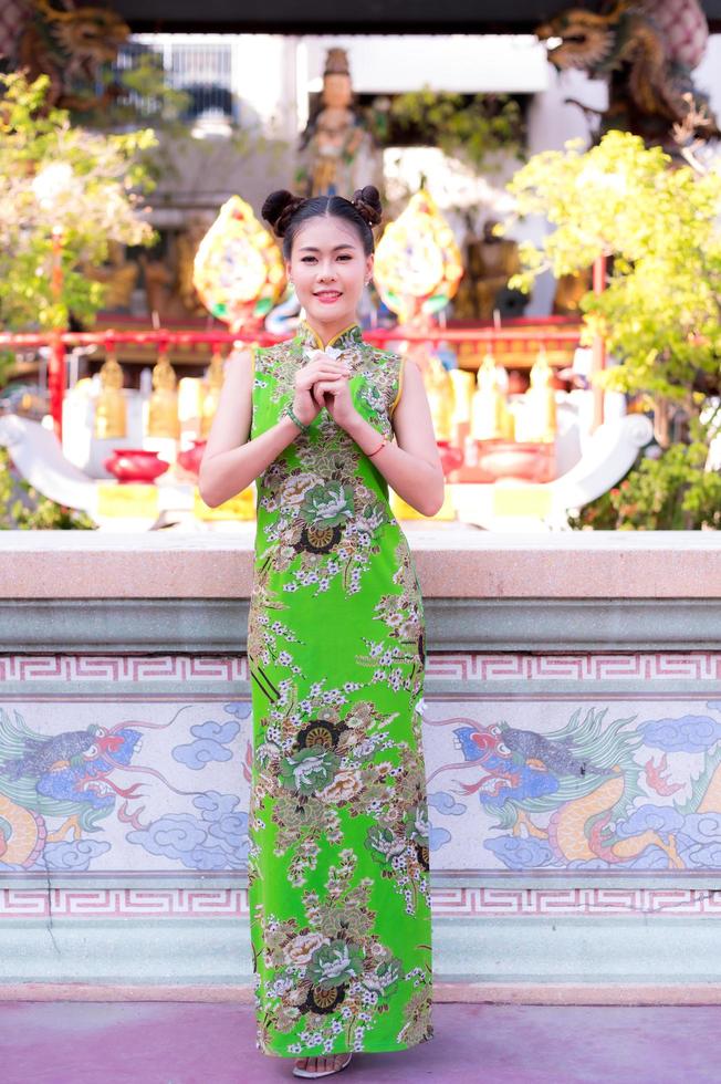 A beautiful Asian woman takes a picture in a Chinese costume photo