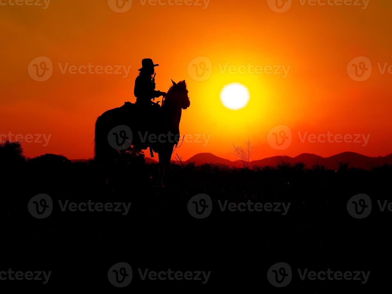 los vaqueros occidentales están sentados a caballo bajo el sol y preparándose para usar armas para protegerse en una tierra que aún no es legal foto