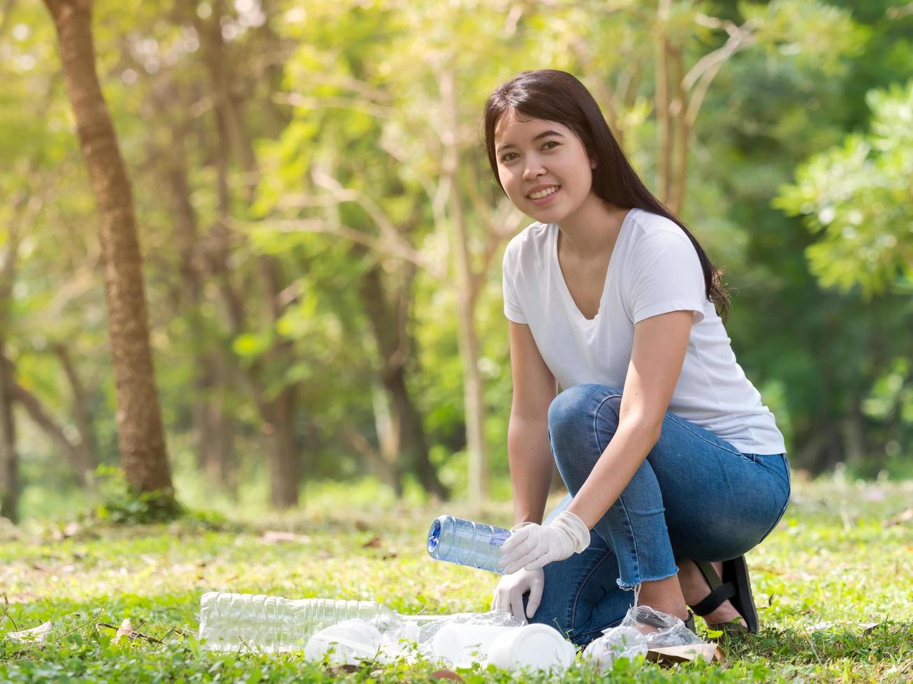 Volunteer women collect plastic water bottles in the park area, From people who refuse to throw in the trash photo