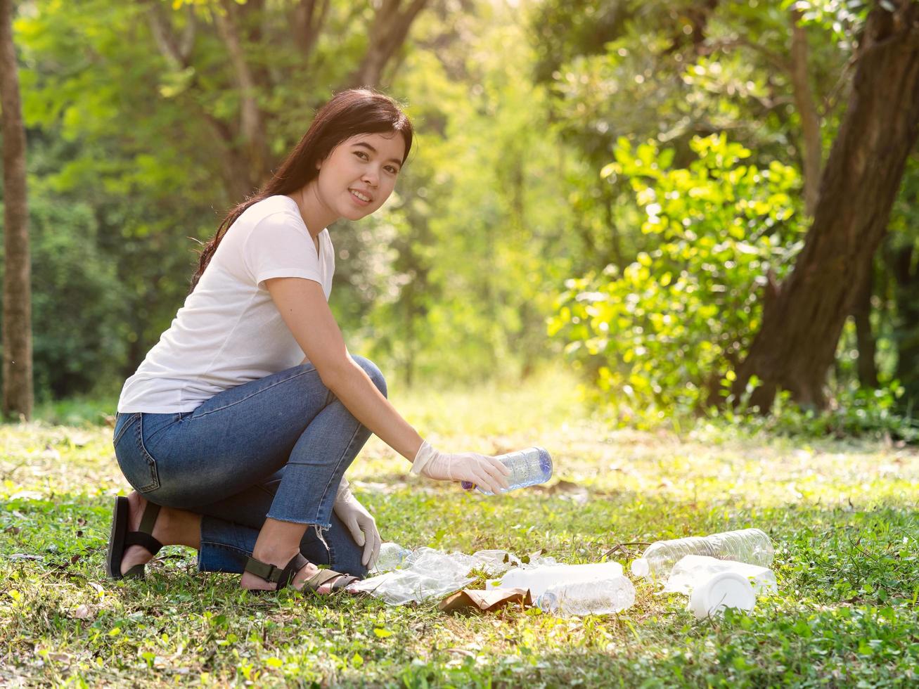 Volunteer women collect plastic water bottles in the park area, From people who refuse to throw in the trash photo