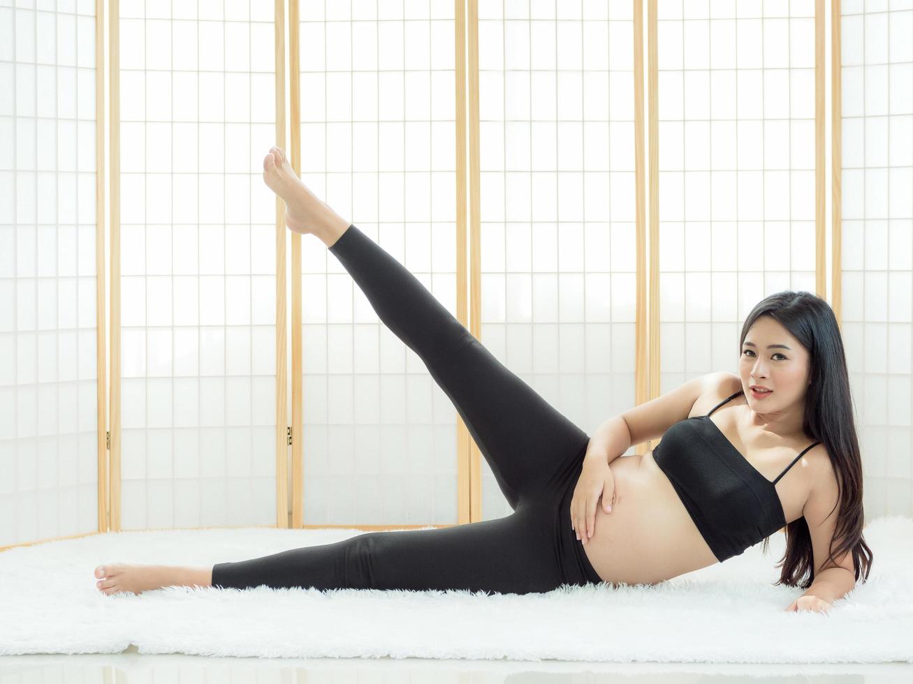 bellas mujeres embarazadas se sientan en el suelo en una habitación japonesa y se relajan con ejercicios de yoga foto