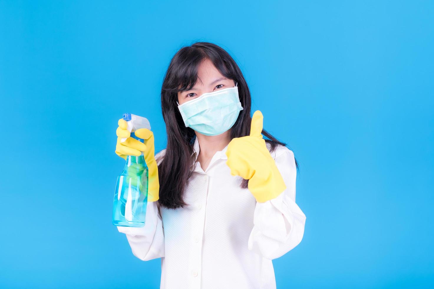 las mujeres asiáticas deben usar máscaras para prevenir la contaminación por polvo y prevenir la infección por virus que se propagan en el aire limpiando con spray de alcohol foto
