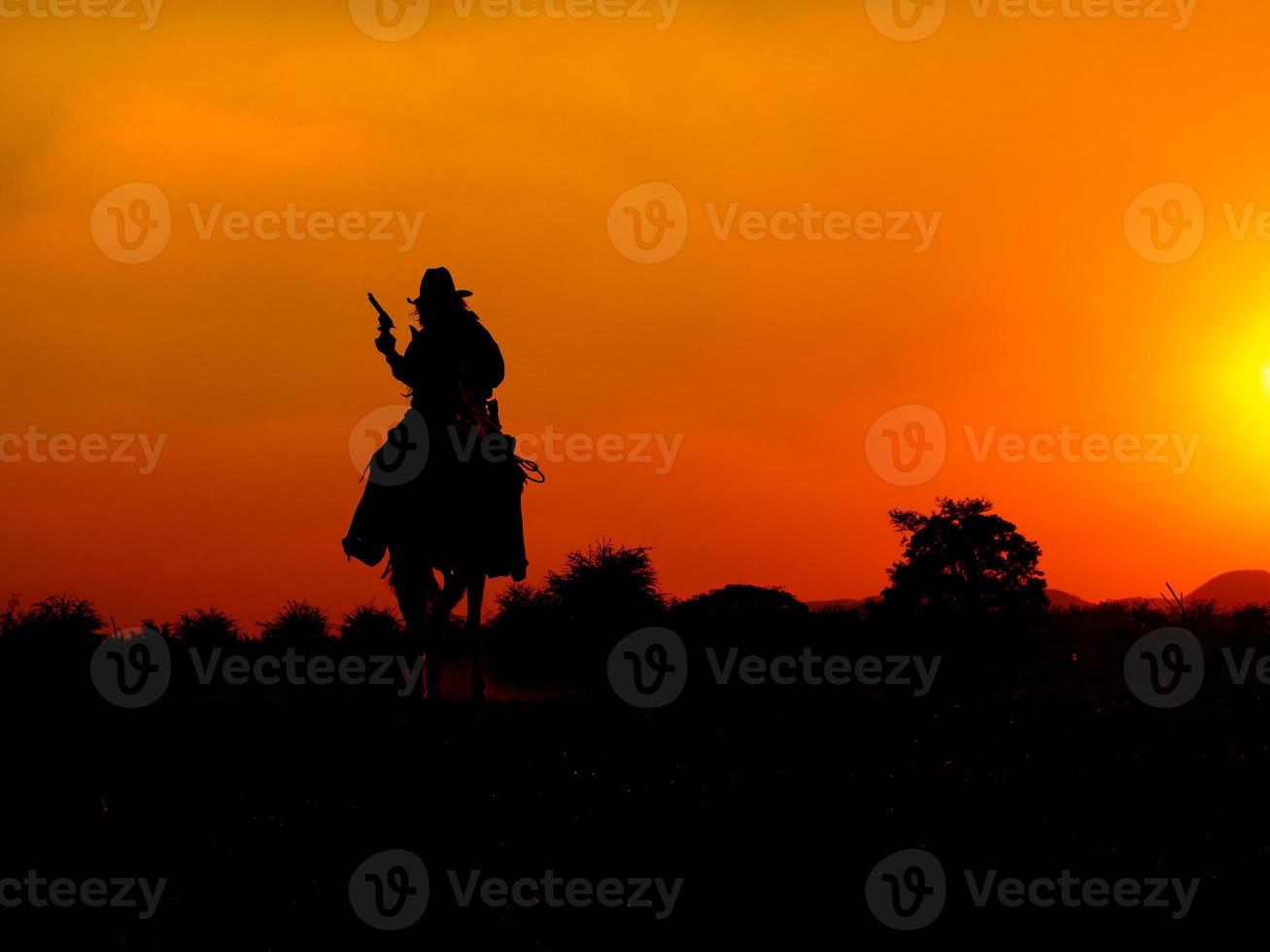 los vaqueros occidentales están sentados a caballo bajo el sol y preparándose para usar armas para protegerse en una tierra que aún no es legal foto