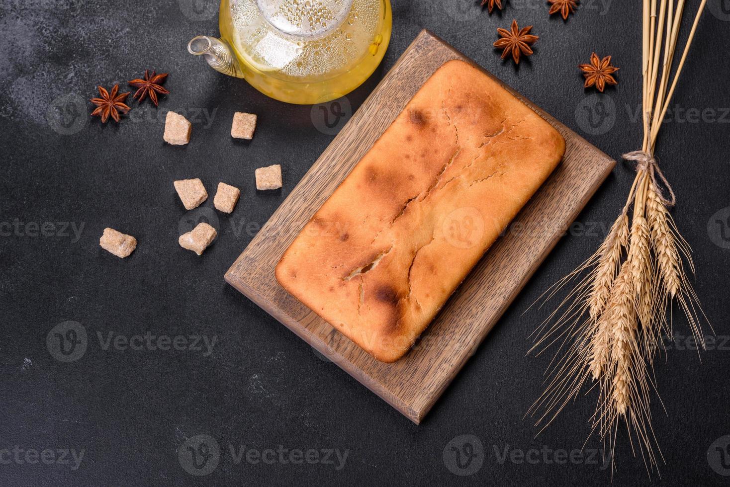 Baked rectangular cupcake with raisins and chocolate on a dark concrete background photo