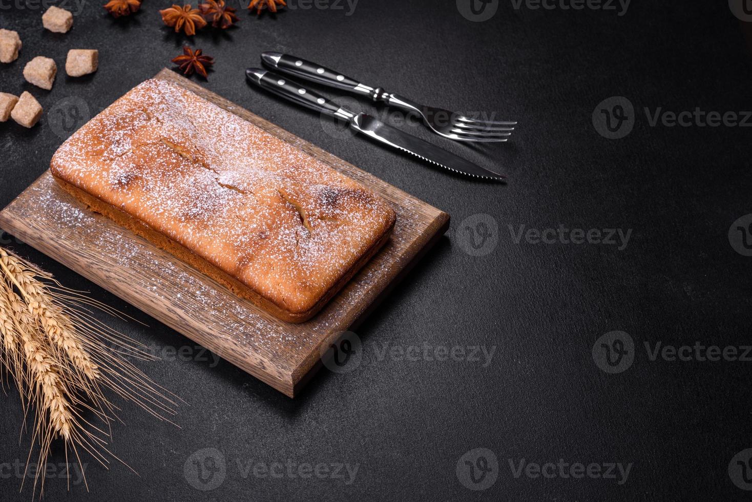 Baked rectangular cupcake with raisins and chocolate on a dark concrete background photo