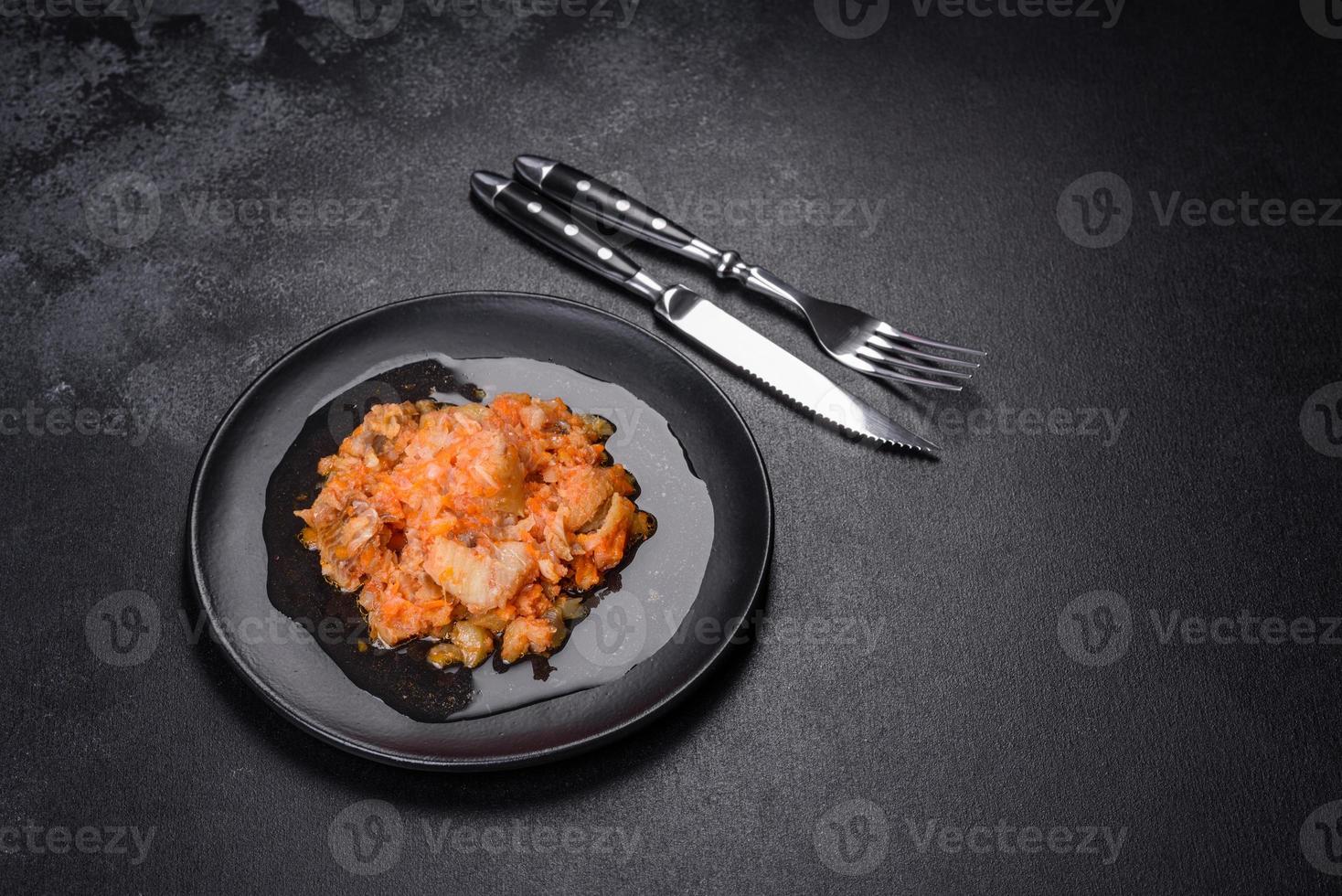 A delicious dish of hake fish in chunks in tomato sauce with spices and herbs photo