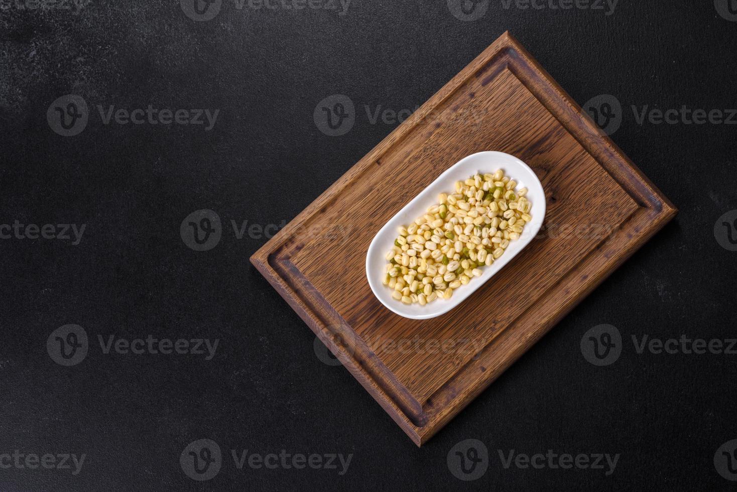 Organics fresh Baby Green Bean Sprouts in white ceramic bowl on a dark concrete background photo